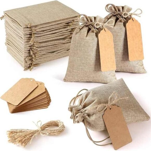 A collection of eco-friendly jute drawstring pouches with attached kraft tags, ideal for sustainable packaging, gifts, and accessories.