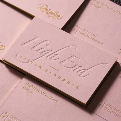 A luxurious letterpress business card with embossed text and gold foil accents, crafted on high-quality textured paper for a premium, elegant look.