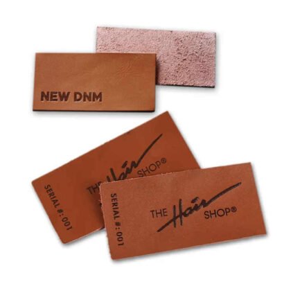 A selection of custom leather labels in rich brown tones featuring embossed designs and logos, ideal for branding on clothing, denim, and accessories.