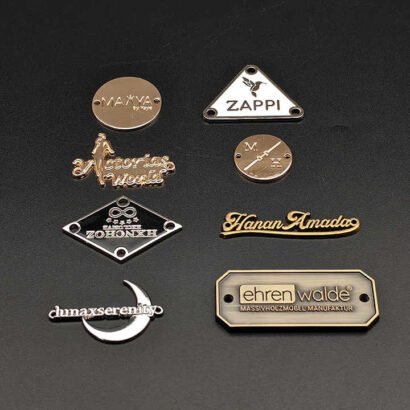 A collection of custom metal labels in various shapes, designs, and finishes, ideal for branding on apparel, bags, furniture, and other premium products.